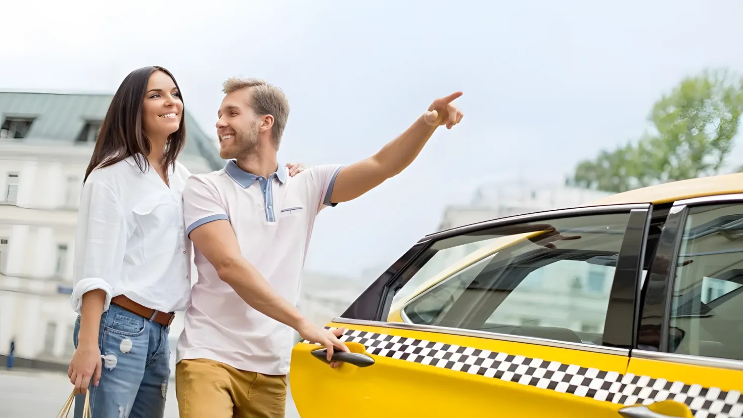 A man and woman standing next to a yellow taxi, both of them smiling. The woman is holding a bag in her hand, and in the background there are buildings, trees, and a clear blue sky.