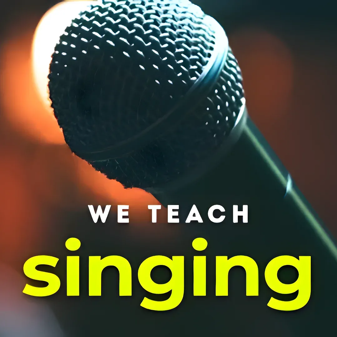 A microphone with the words "We Teach Singing" written on it, set against a blurred background.