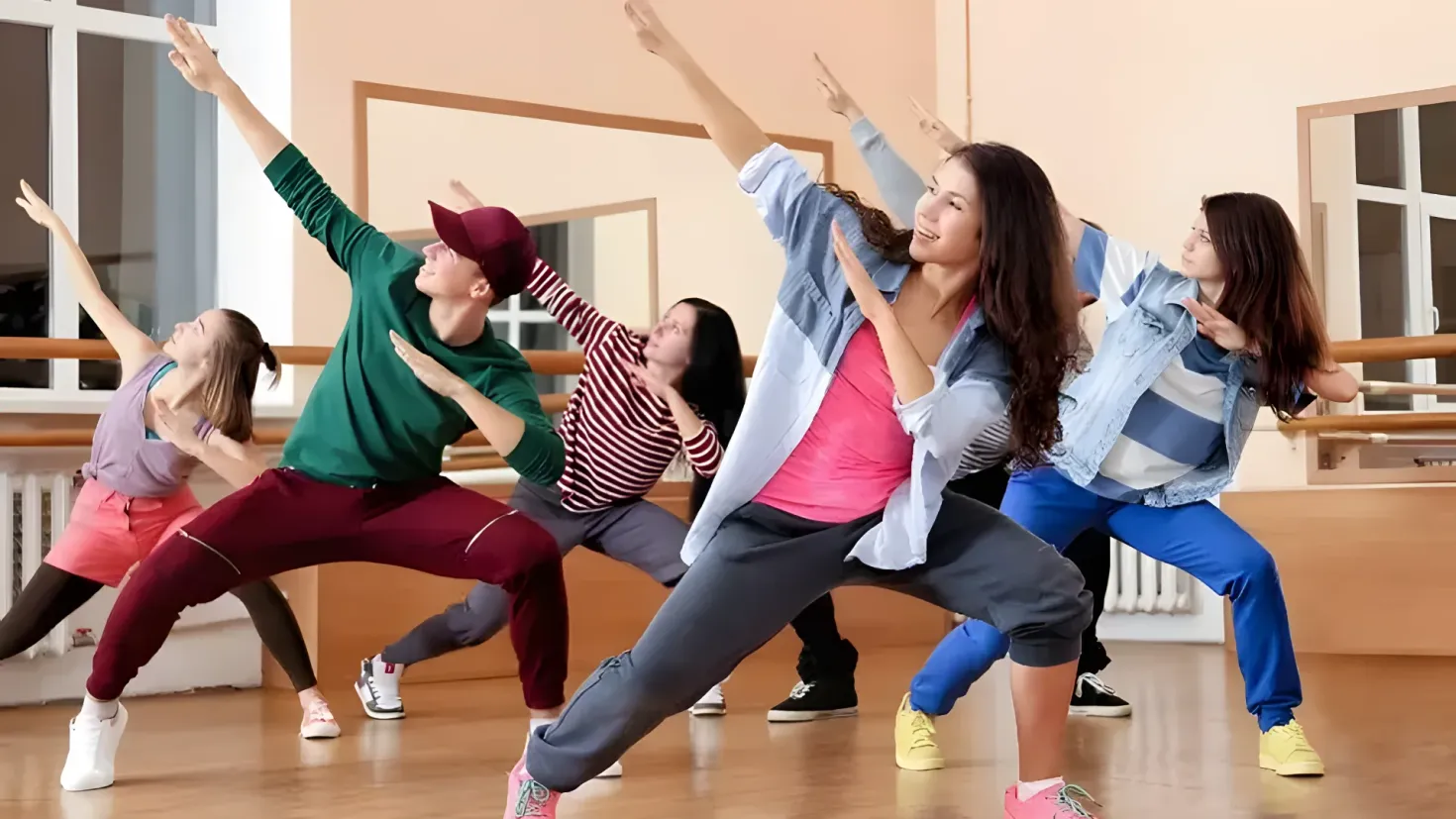 A group of young people dancing in a dance studio, with a wall in the background and windows on either side. They appear to be in the middle of a choreography class, as indicated by the YouTube logo in the corner.